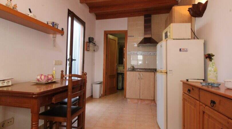 Küche mit Holzbalkendecke, Esstisch, Einbauküche und Kühlschrank in Palma de Mallorca Wohnung