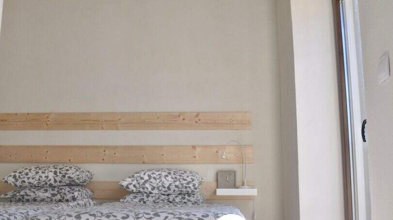 Helles Schlafzimmer der Finca in Campanet mit Doppelbett, Holzbalkendecke und Deckenventilator