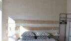 Schlafzimmer der Finca in Campanet mit Doppelbett, Holzbalkendecke und Deckenventilator