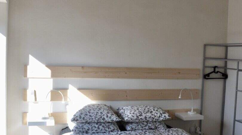 Schlafzimmer der Finca in Campanet mit Doppelbett, Holzbalkendecke und Deckenventilator