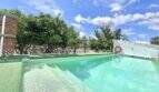 Finca Campanet: Pool mit türkisem Wasser, Rettungsring, Obstbäume und blauer Himmel