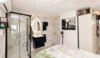 Modernes Schlafzimmer mit begehbarer Dusche, Marmorwänden und beleuchtetem Spiegel in Finca bei Palma