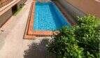 Rechteckiger Pool mit blauem Wasser und Terrakotta-Fliesen im Innenhof der Wohnanlage in Palma de Mallorca