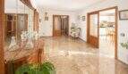 Eleganter Wohnbereich mit Marmorböden, Holzvertäfelungen und Blick in Küche der Wohnung in Palma Es Rafal