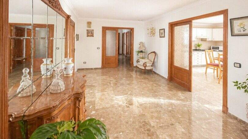 Eleganter Wohnbereich mit Marmorböden, Holzvertäfelungen und Blick in Küche der Wohnung in Palma Es Rafal