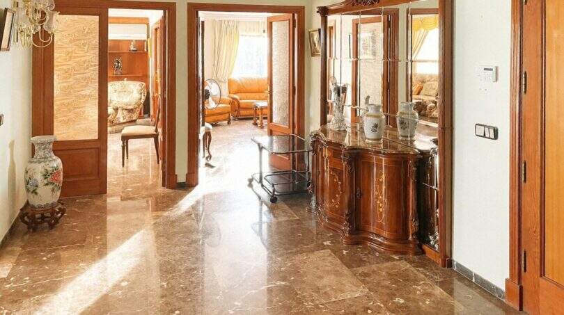 Eleganter Eingangsbereich mit Marmorboden, Holzvertäfelung und klassischen Möbeln in Palma-Wohnung