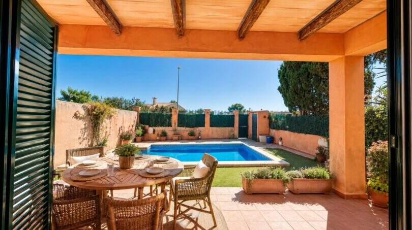 Covered terrace with direct pool access and surrounding garden area