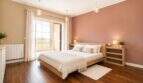 Hauptschlafzimmer mit Balkonzugang, Fußbodenheizung und eleganter Pendelleuchtenbeleuchtung