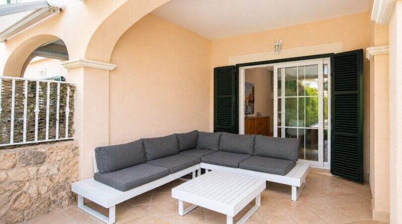 Überdachte Terrasse mit eleganten Säulenarkaden und direktem Hauseingang