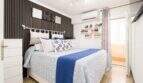 Helles Schlafzimmer mit Doppelbett, blauer Bettwäsche, Klimaanlage und dekorativem Akzentpaneel in Palma