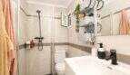 Modernes Badezimmer mit Glasdusche, schwarzen Armaturen und Wandregalen in Palma-de-Mallorca-Wohnung