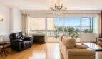 Bright living room with chandelier, leather armchair and sea view balcony in Palma de Mallorca