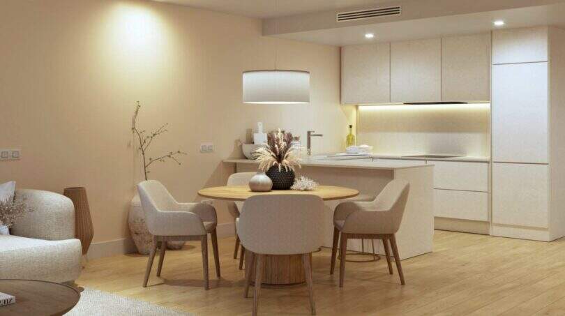 Bright living-dining room with wooden table, modern kitchen and warm design in new building Palma de Mallorca