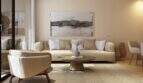 Bright living room with cream sofa, round table and abstract wall art in the new Palma de Mallorca building