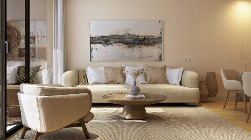Bright living room with cream sofa, round table and abstract wall art in the new Palma de Mallorca building