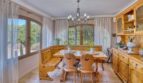 Helles Esszimmer der Villa in Marratxí mit rustikalen Holzmöbeln, Kronleuchter und Blick in den Garten.