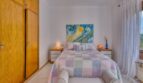 Helles Schlafzimmer der Villa in Marratxí mit Doppelbett, buntem Patchwork-Überwurf und Einbauschrank