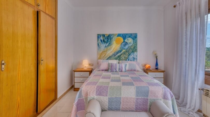 Helles Schlafzimmer der Villa in Marratxí mit Doppelbett, buntem Patchwork-Überwurf und Einbauschrank