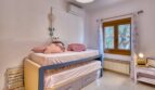 Kinderzimmer der Villa in Marratxí mit Etagenbett, Klimaanlage, Heizkörper und Fenster mit Gartenblick.