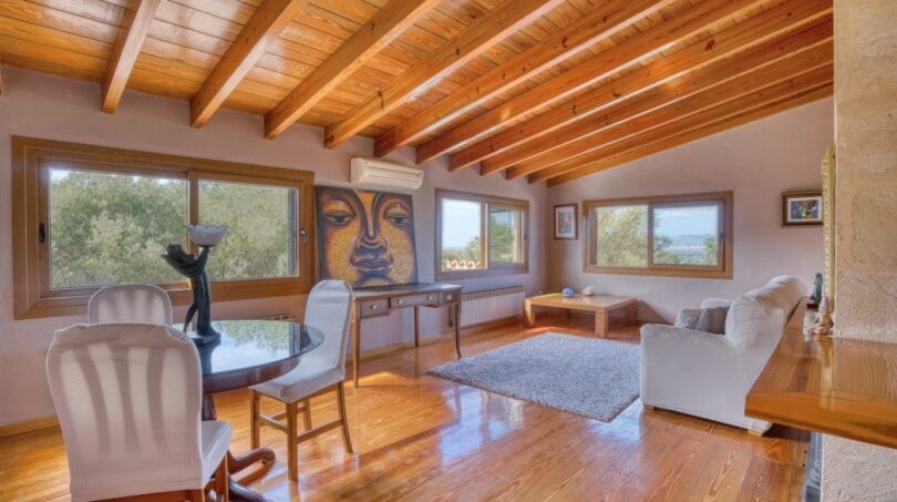 Helles Wohnzimmer der Villa in Marratxí mit Holzbalkendecke, Parkettboden und Buddha-Kunstwerk