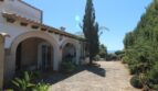 Eingangsbereich einer mediterranen Villa in Marratxí mit Rundbögen, Steinpflaster und üppigem Grün