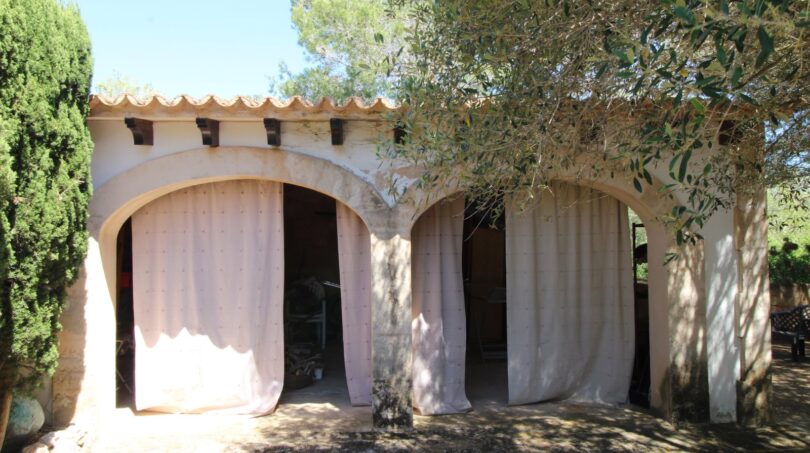 Überdachte Außenterrasse mit Rundbögen und Vorhängen, umgeben von Olivenbäumen, Villa Marratxí