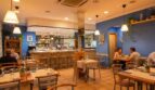 Restaurante mediterráneo con paredes azules, lámparas colgantes, bar e iluminación acogedora en Palma de Mallorca.