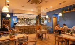 Mediterranes Restaurant mit blauen Wänden, Hängeleuchten, Bar und stimmungsvoller Beleuchtung in Palma de Mallorca.