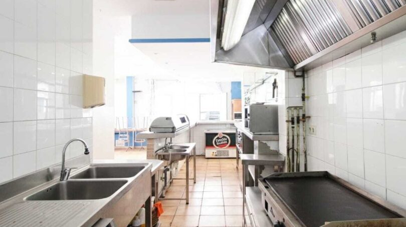 Gewerbliche Profiküche mit Edelstahlausstattung, Dunstabzug, Doppelspüle und Grillplatte in Strandnähe Mallorca.