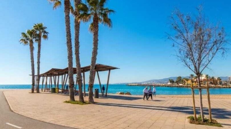 Strandpromenade in Palma de Mallorca mit Palmen, Holzpavillon und türkisblauem Mittelmeer