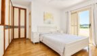 Dormitorio luminoso de la villa en Llucmajor con cama doble, armario empotrado y acceso al balcón