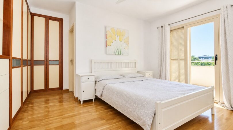 Dormitorio luminoso de la villa en Llucmajor con cama doble, armario empotrado y acceso al balcón