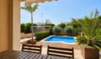 Terraza cubierta con muebles de madera y piscina privada, rodeada de palmeras y zonas verdes, villa Llucmajor
