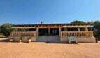Außenansicht einer mallorquinischen Finca mit großer Veranda, Säulen und weitläufigem Vorplatz in S'Illot.