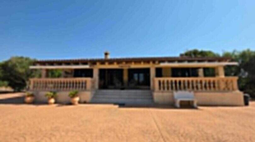 Außenansicht einer mallorquinischen Finca mit großer Veranda, Säulen und weitläufigem Vorplatz in S'Illot.