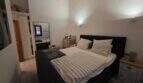 Schlafzimmer der Finca S'Illot mit Doppelbett, Holzbalkendecke und Spiegelschrank
