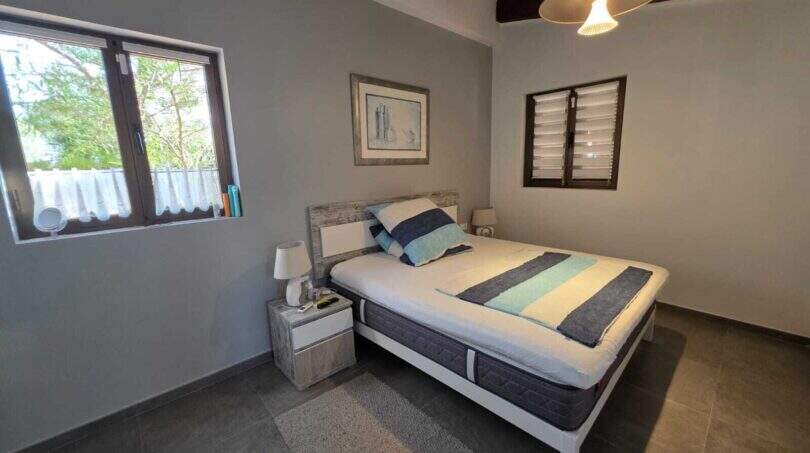 Helles Schlafzimmer der Finca S'Illot mit Doppelbett, Holzbalkendecke und mediterranem Ausblick
