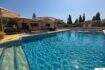 Finca S'Illot: Großer blauer Pool mit Sonnenterrasse, Pergola und mediterranem Garten im Hintergrund.