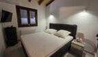 Schlafzimmer der Finca S'Illot mit Doppelbett, Holzbalkendecke, TV und Klimaanlage