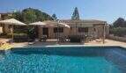 Finca S'Illot: Großer Außenpool mit Terrasse, Liegestühlen, Sonnenschirmen und Schaukelstühlen vor dem Steinhaus.