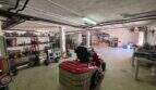 Geräumige Garage der Finca S'Illot mit Aufsitzrasenmäher, Werkzeugregalen und viel Stauraum.