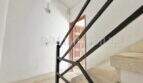 Staircase with black metal railing, marble stairs and wooden door in renovation apartment, Playa de Palma