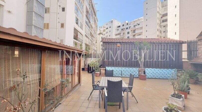 Geräumige Dachterrasse mit Sitzgruppe, Pflanzen und Holzelementen, umgeben von Wohngebäuden in Palma