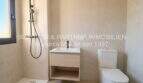 Baño moderno del apartamento esquinero de nueva construcción en Cala Millor con ducha, lavabo e inodoro en colores claros.