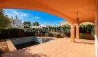 Überdachte Terrasse mit Pool und gepflegtem Garten eines Einfamilienhauses in Sa Coma, nahe Strand.