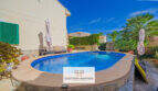 Ovaler Pool mit Sonnenliegen und Palmen im mediterranen Garten des Ferienhauses in Cala Murada