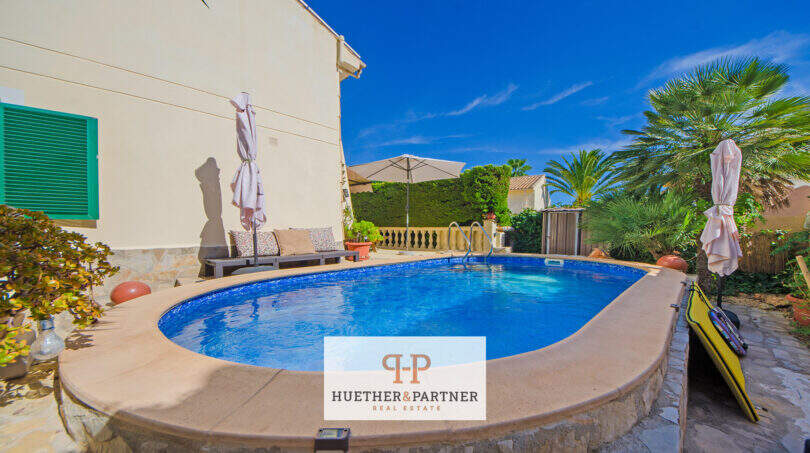 Ovaler Pool mit Sonnenliegen und Palmen im mediterranen Garten des Ferienhauses in Cala Murada