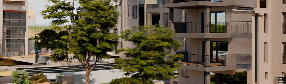 Modern residential complex in Cala Millor with balconies, well-maintained inner garden, trees and pool near the beach.