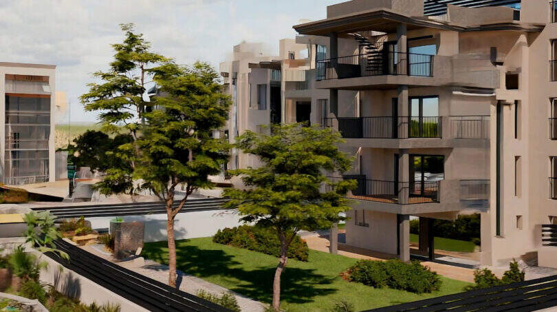 Modern residential complex in Cala Millor with balconies, well-maintained inner garden, trees and pool near the beach.