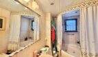 Badezimmer der Wohnung in Palma-City mit Whirlpool-Badewanne, Dusche, Waschbecken und großem Spiegel.